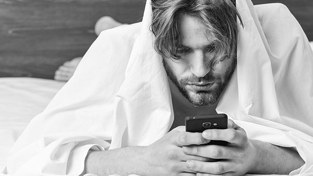 Man scrolling through Grindr on phone