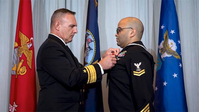 Information Systems Technician Second Class Thomas James, right, Defense Intelligence Agency, receives the Navy and Marine Corps Medal