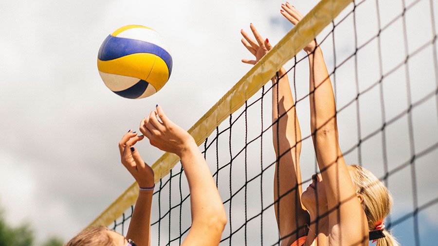 Girls play volleyball (via Depositphotos)